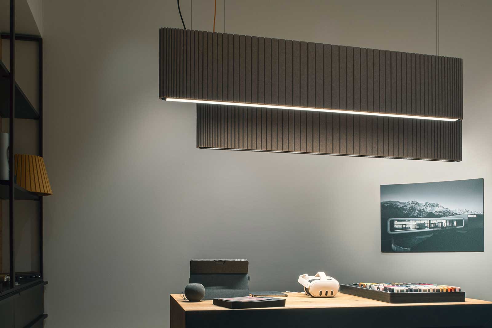 Oval pendant luminaire with sound-absorbing material for improved room acoustics.