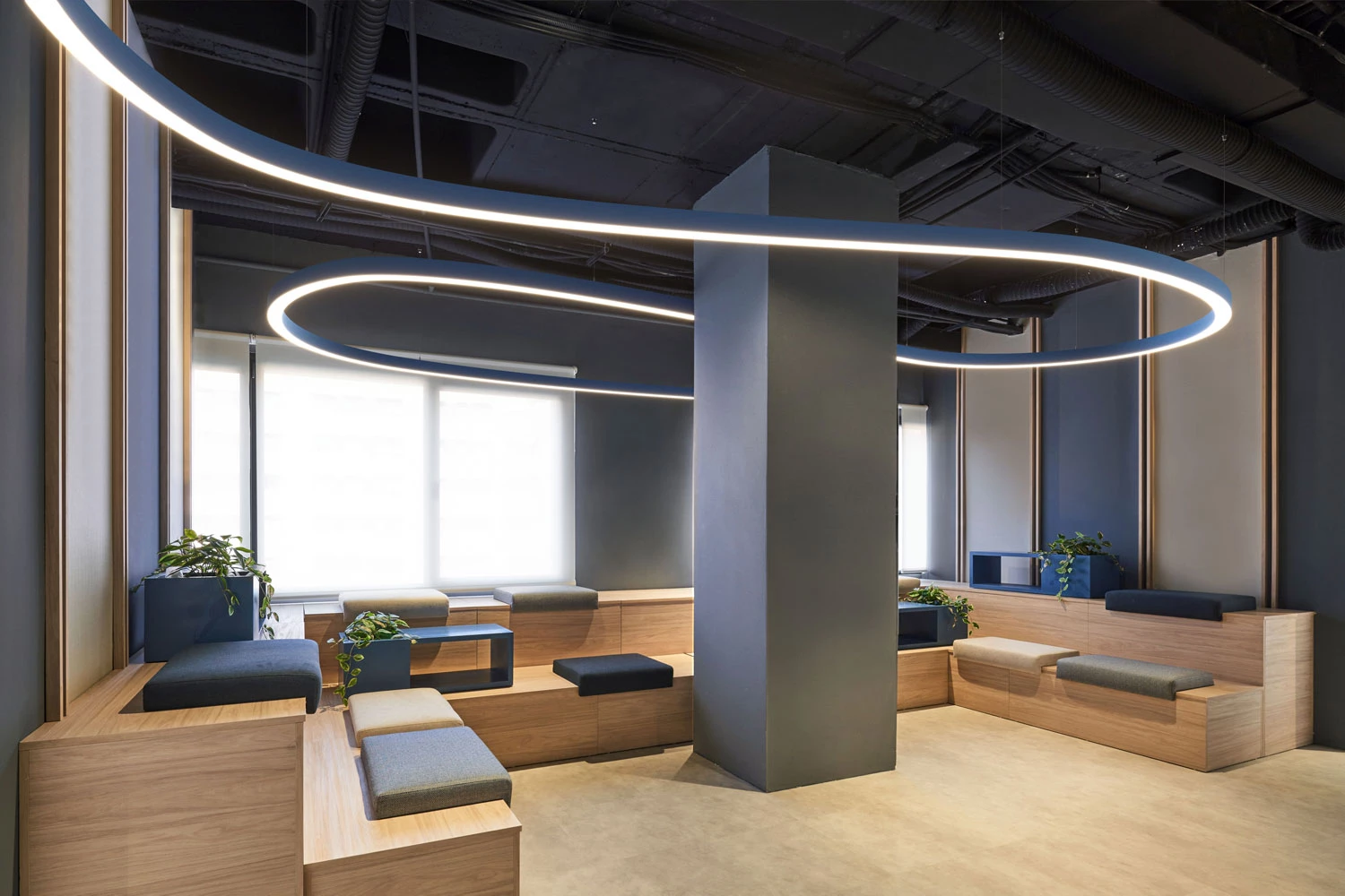 A flexible SUPER-G ceiling light in a curved blue design provides extraordinary lighting design and modern lighting in a waiting area.