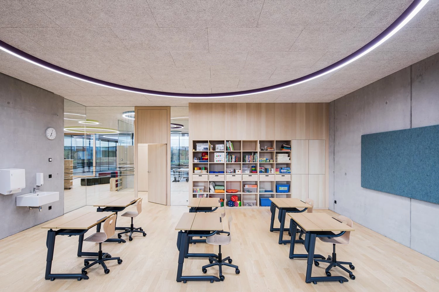 Large, round surface-mounted luminaire in purple in a classroom in a primary school.