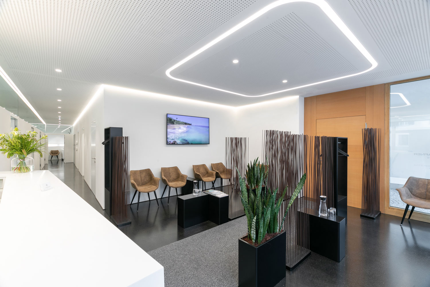Modern ceiling lighting provides uniform and friendly illumination of the waiting room in a doctor's office.