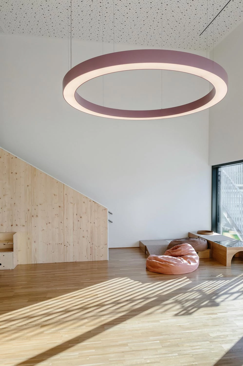 Large purple ring luminaire as a central lighting element in the kindergarten