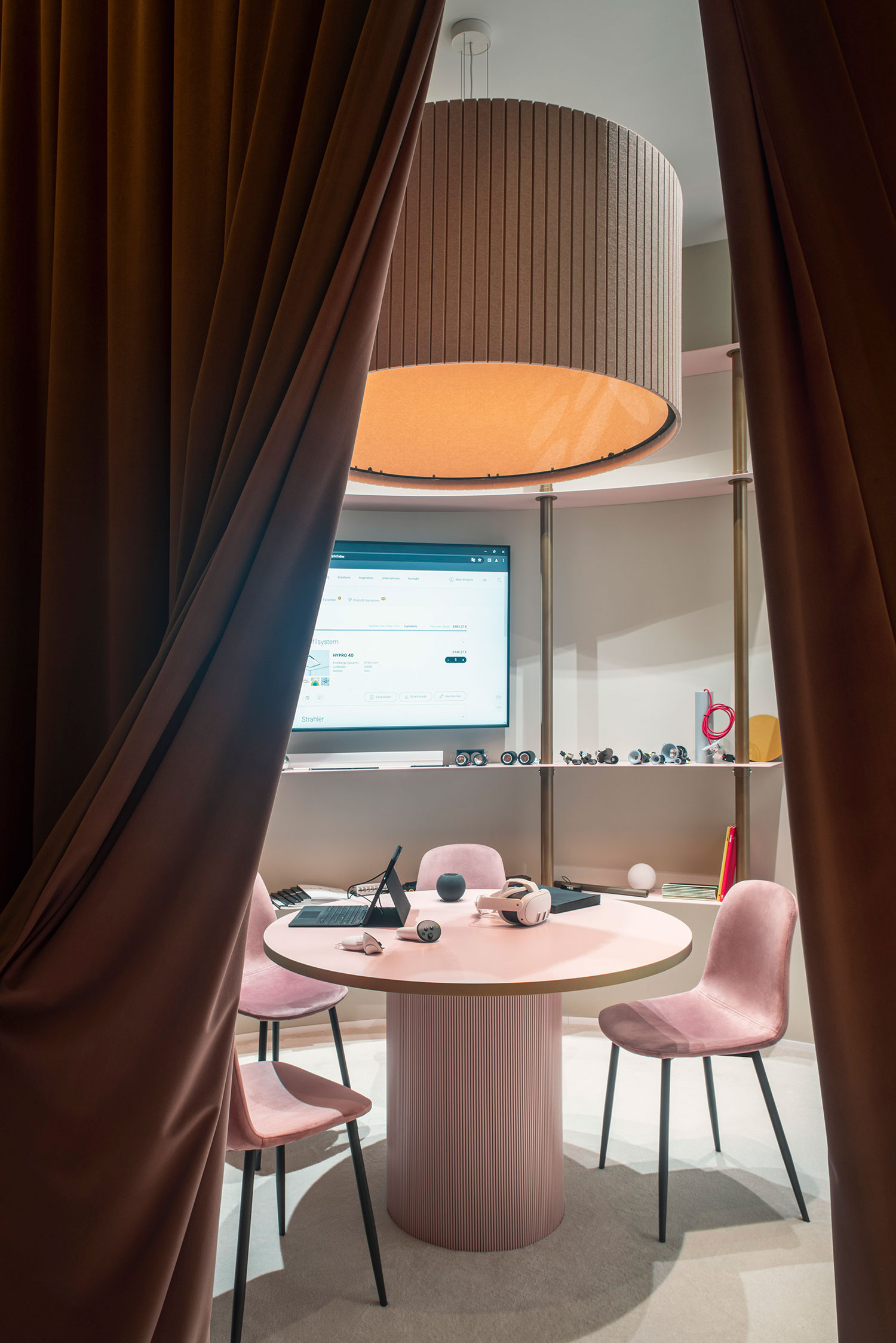 Modern round acoustic pendant luminaire above a meeting table for optimised room acoustics.