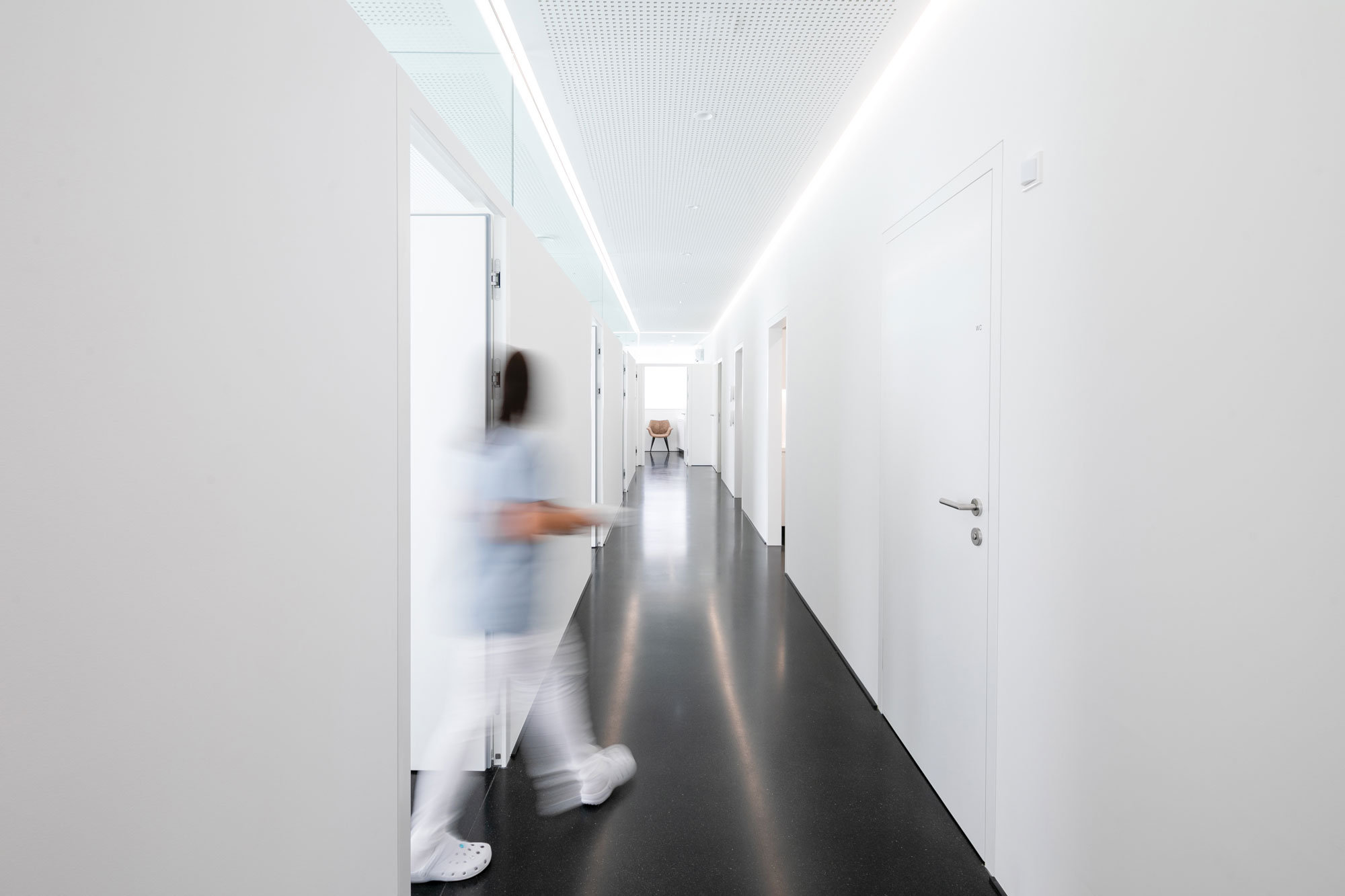 The modern lighting in the hallway of a dental practice integrates a guidance system that offers patients orientation through targeted lighting.