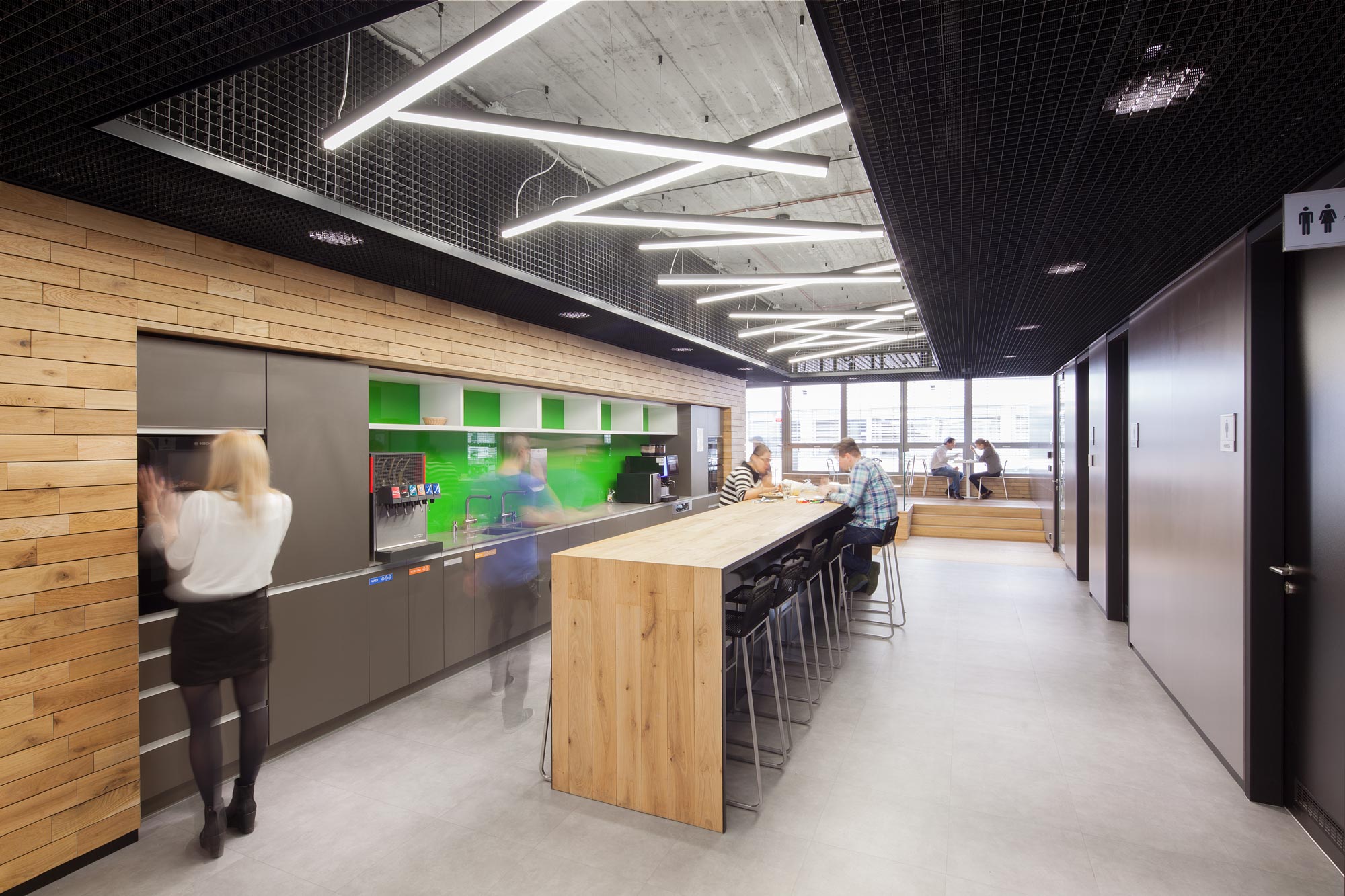 Modern lighting solution for recreational areas. Chaotically arranged profile systems on the ceiling. Kitchen for teachers in a school.