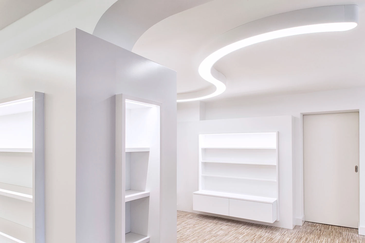 A white SUPER-G ceiling light with curved, flexible lines implements a modern lighting concept for creative interior design.